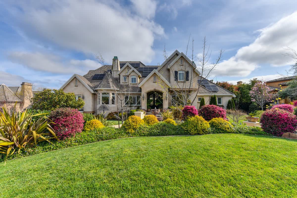 Layered color beds in front of a stone house