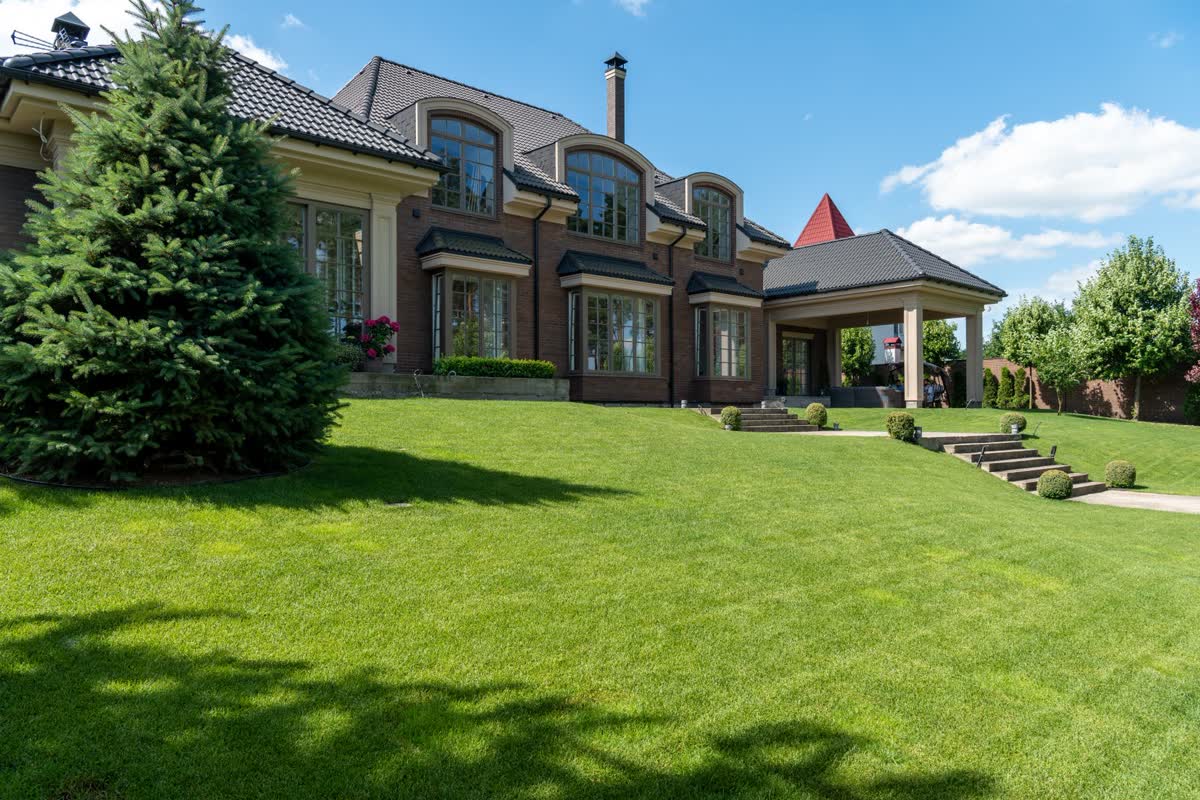 Estate lawn rolling up to a brick home
