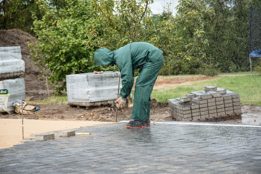 Worker laying paving stones for a new patio
